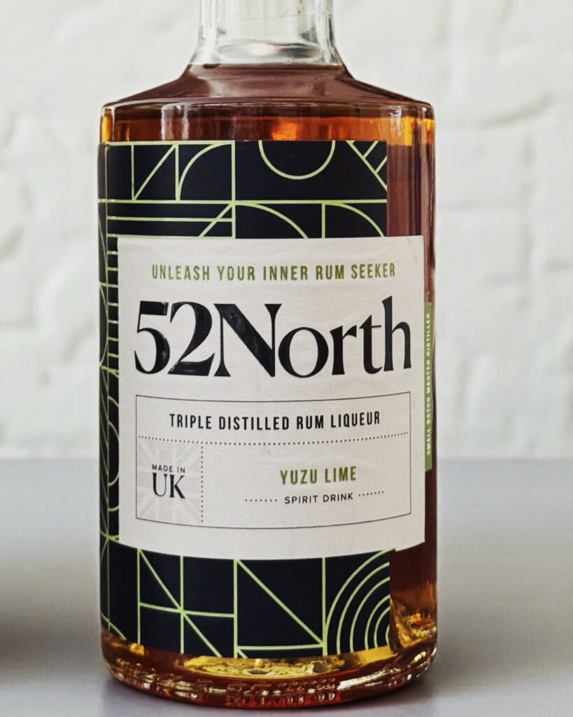 A medium closeup of a 52North Drinks Yuzu Lime Rum Liqueur bottle.